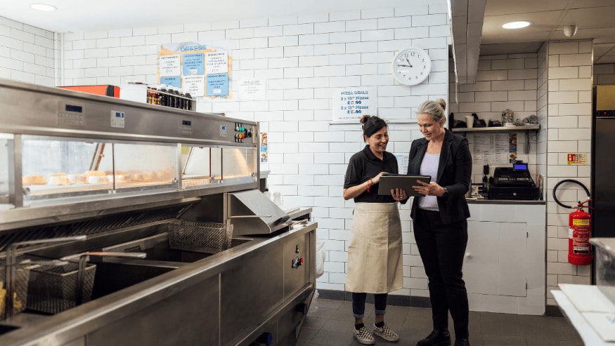 Two quick service restaurant workers talking